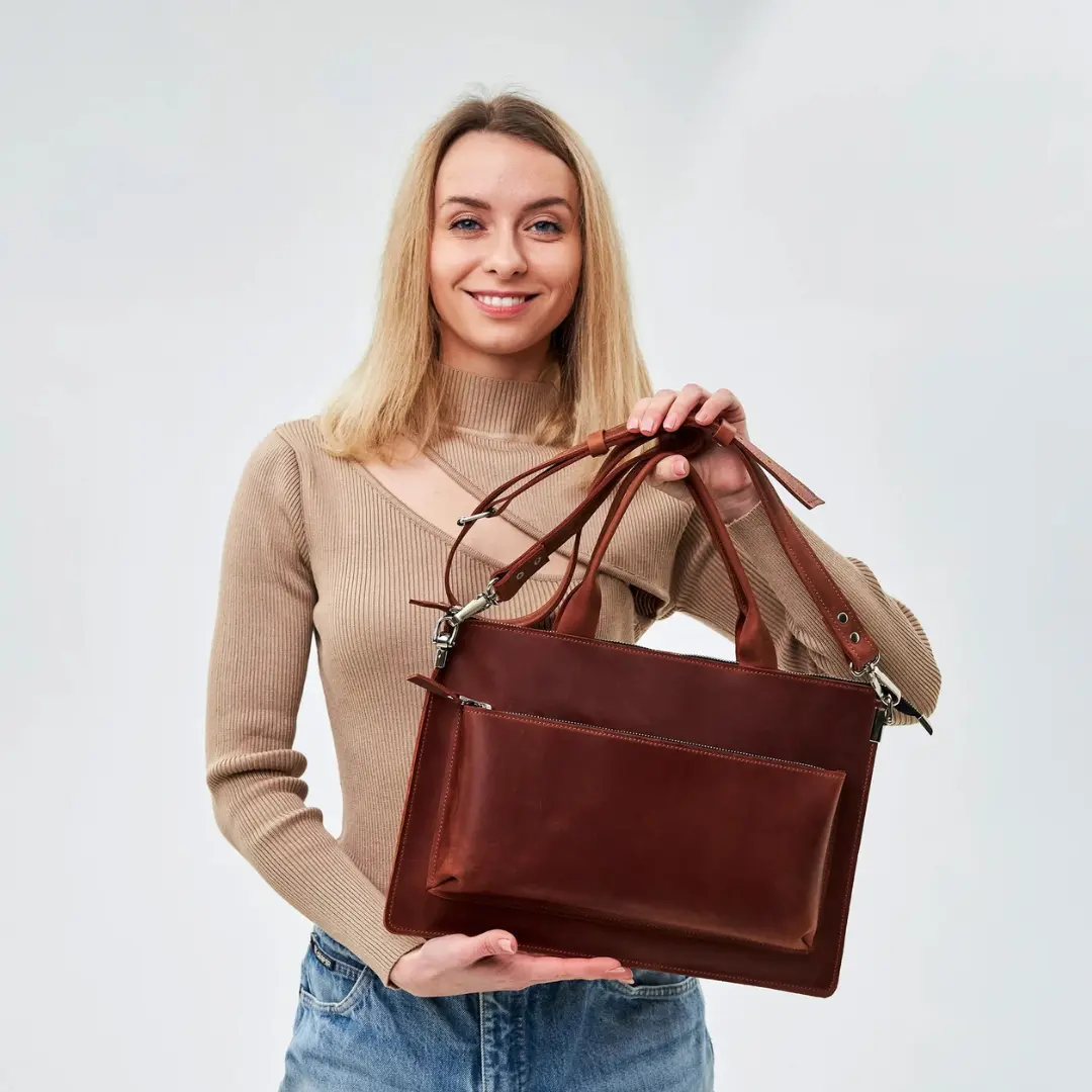 Stainless steel vacuum insulated tumbler with handle placed on wooden table inside modern coffee shop